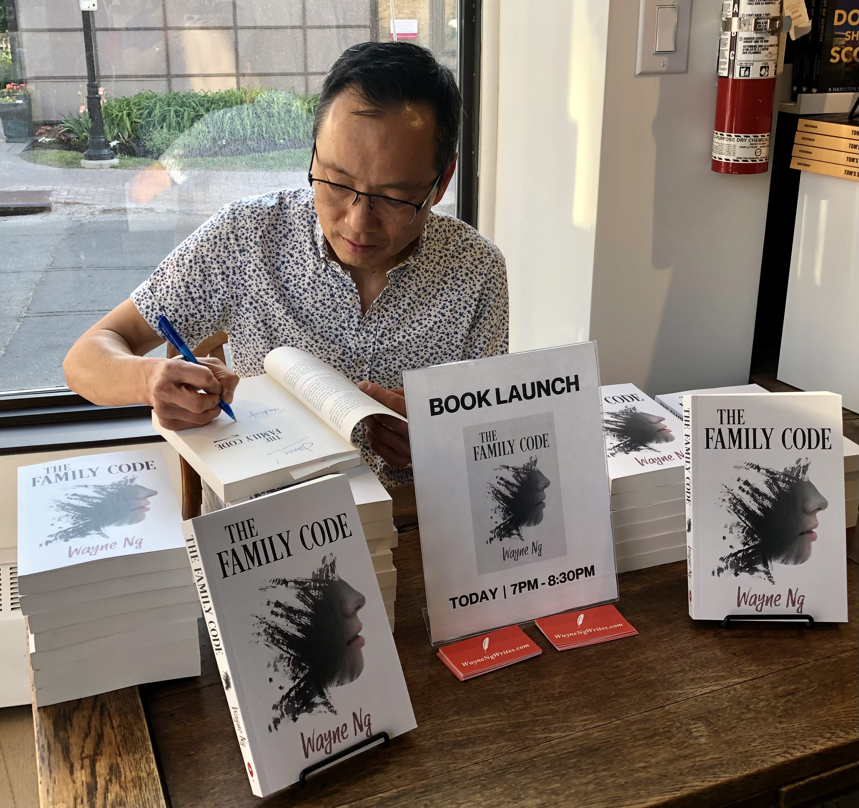 Wayne Ng signing books at the launch of THE FAMILY CODE at The Spaniel's Tale Bookstore