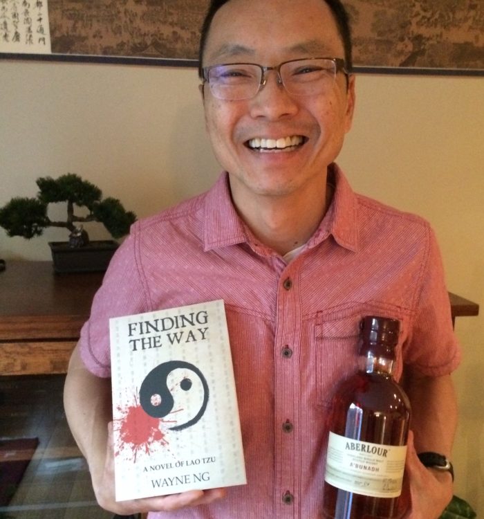 Wayne Ng with book and bottle of scotch