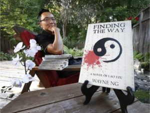 Wayne Ng sitting in backyard with his novel