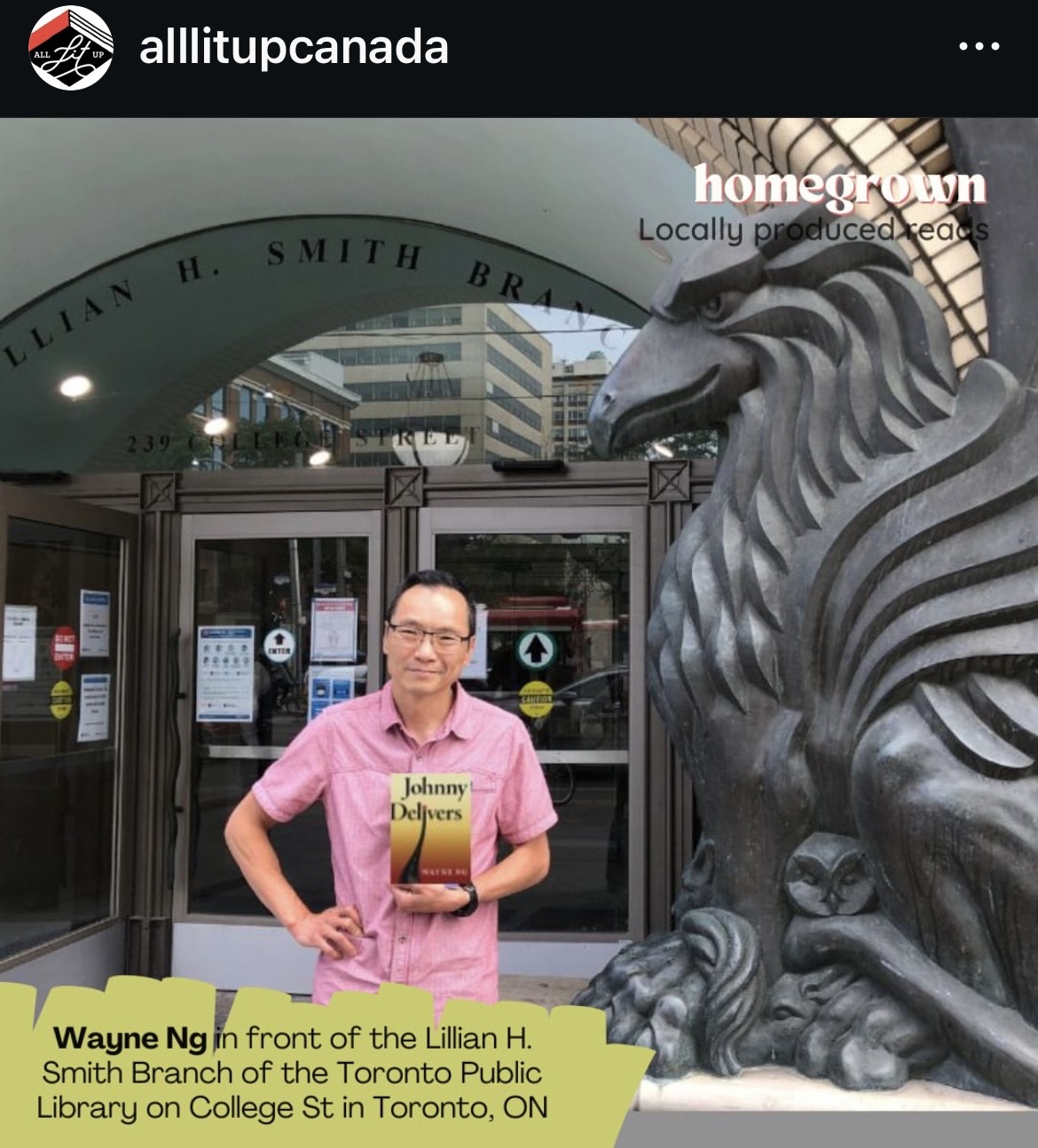 Wayne Ng is pictured holding a copy of JOHNNY DELIVERS before the Lillian H. Smith Branch of the Toronto Public Library on College St, Toronto