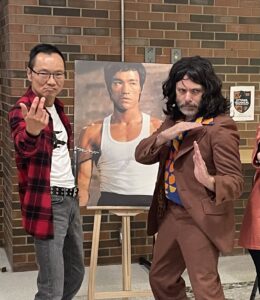 Wayne Ng and Alan Neal pose with a poster of Bruce Lee